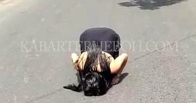 Terlihat seorang wanita muda dengan pakaian yang mirip kemben berwarna hitam bertingkah aneh di tengah Jalan Turi, Kecamatan Medan Kota.